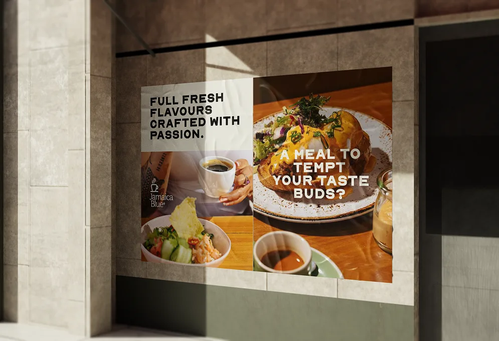 Poster on a concrete wall: “Full fresh flavours crafted with passion” beside a plated meal