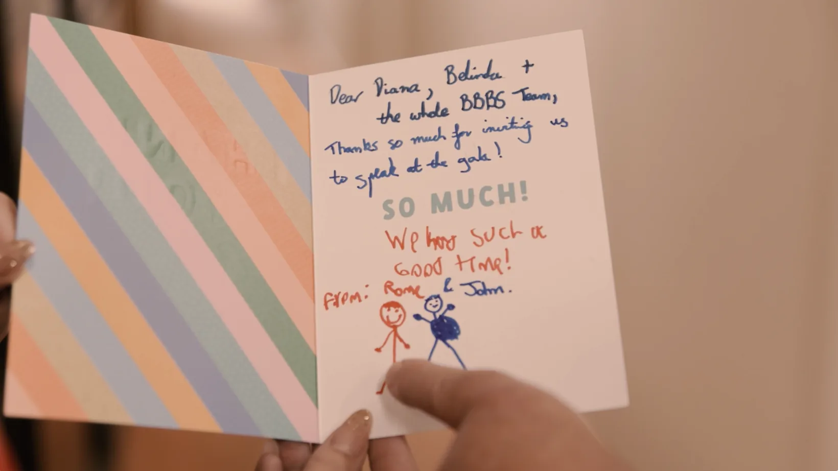 A handwritten, hand-illustrated thank-you card held open to the camera