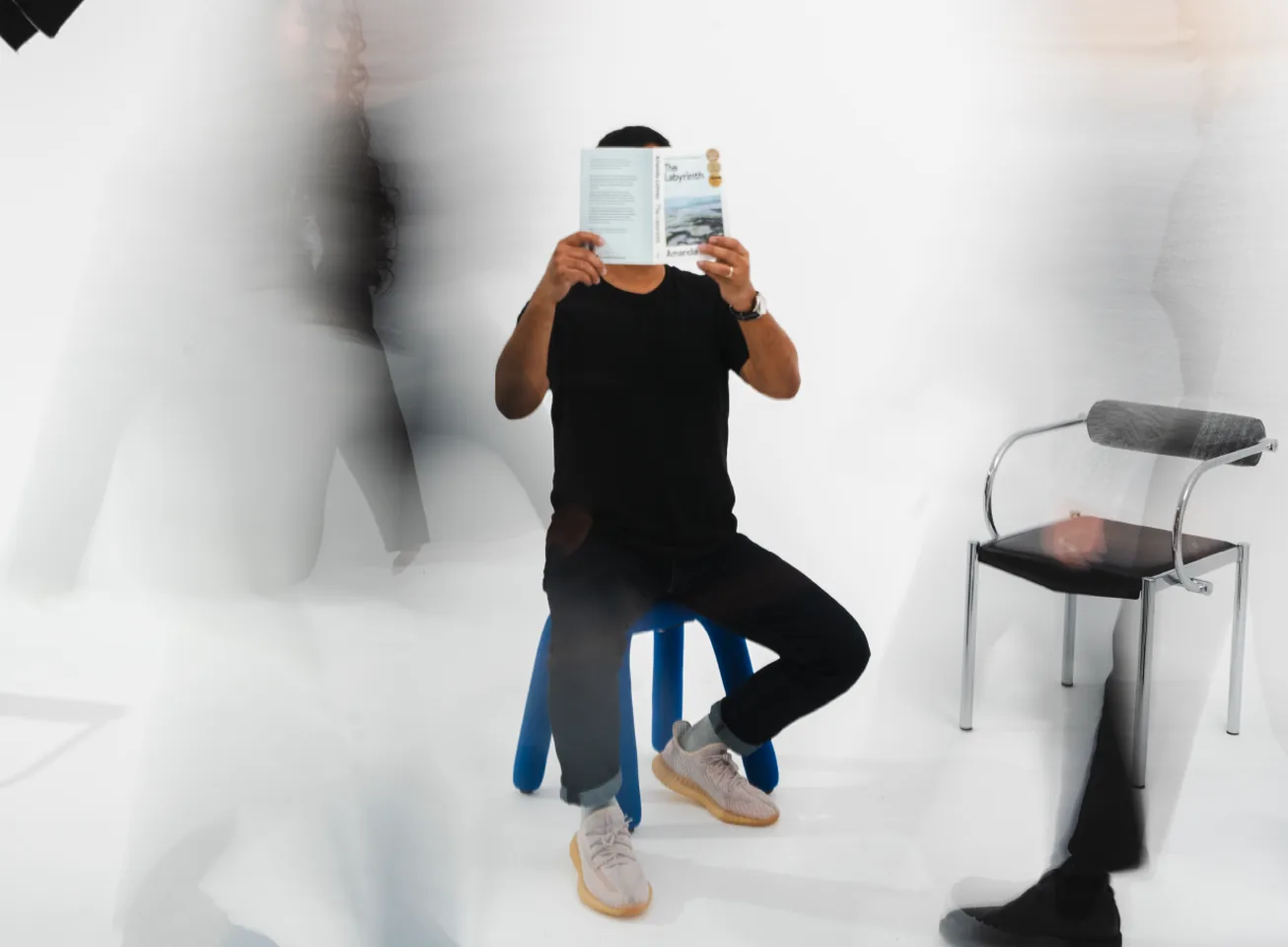 Man reading a magazine as people blur past