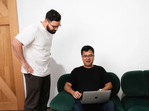 Two Media Exchange team members reviewing campaign results on a laptop