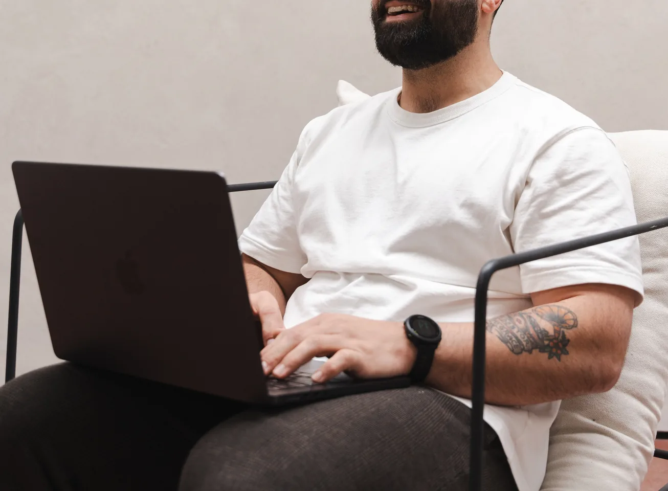 Man in a white T-shirt working on a laptop